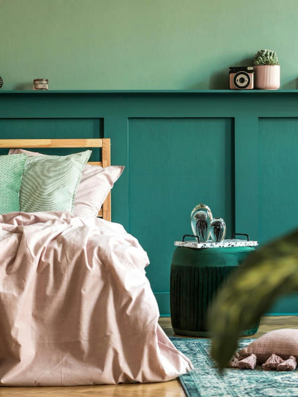 Najlepsze kolory do sypialni w zielonym kolorze z przytulnymi poduszkami i kocami