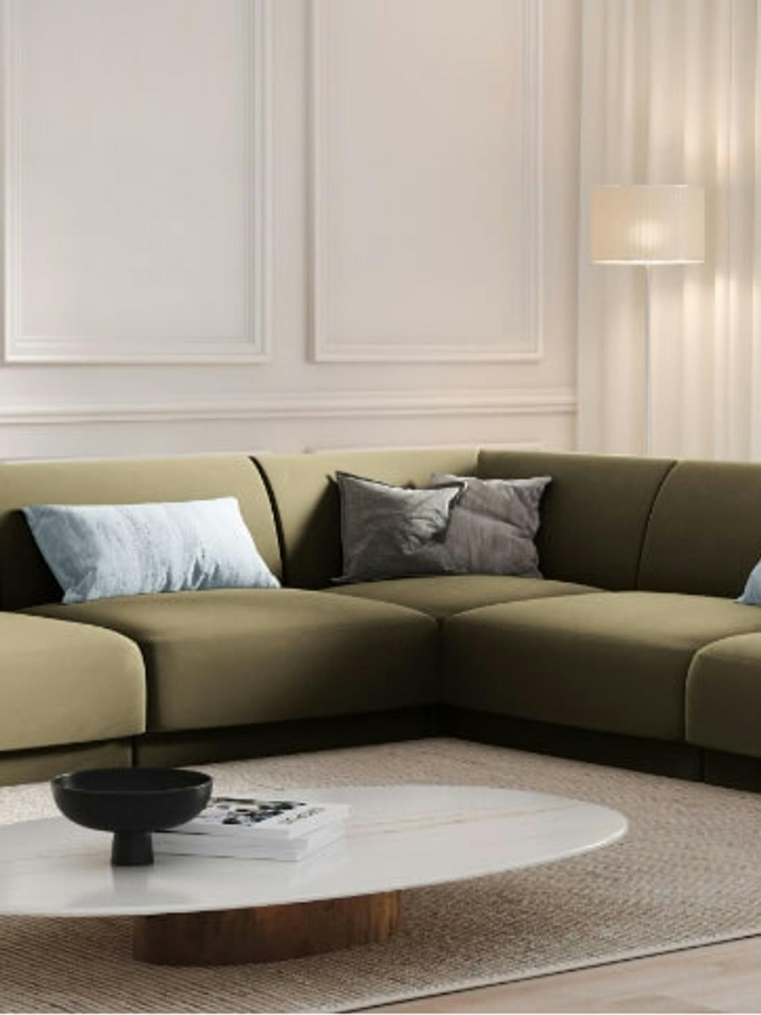 Salon w stylu minimalistycznym z zieloną sofą w centralnym miejscu